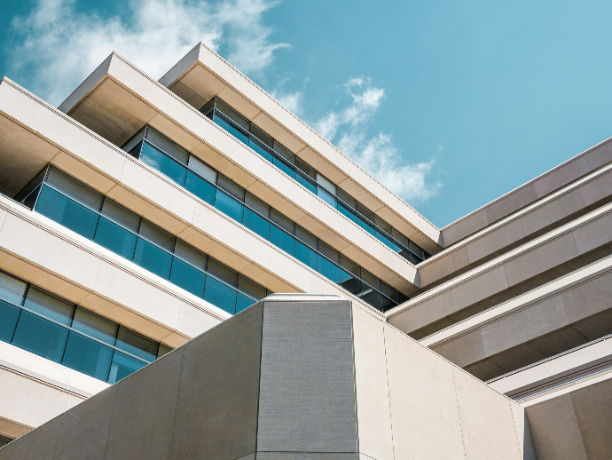 low angle photo of beige concrete building under cloudy sky